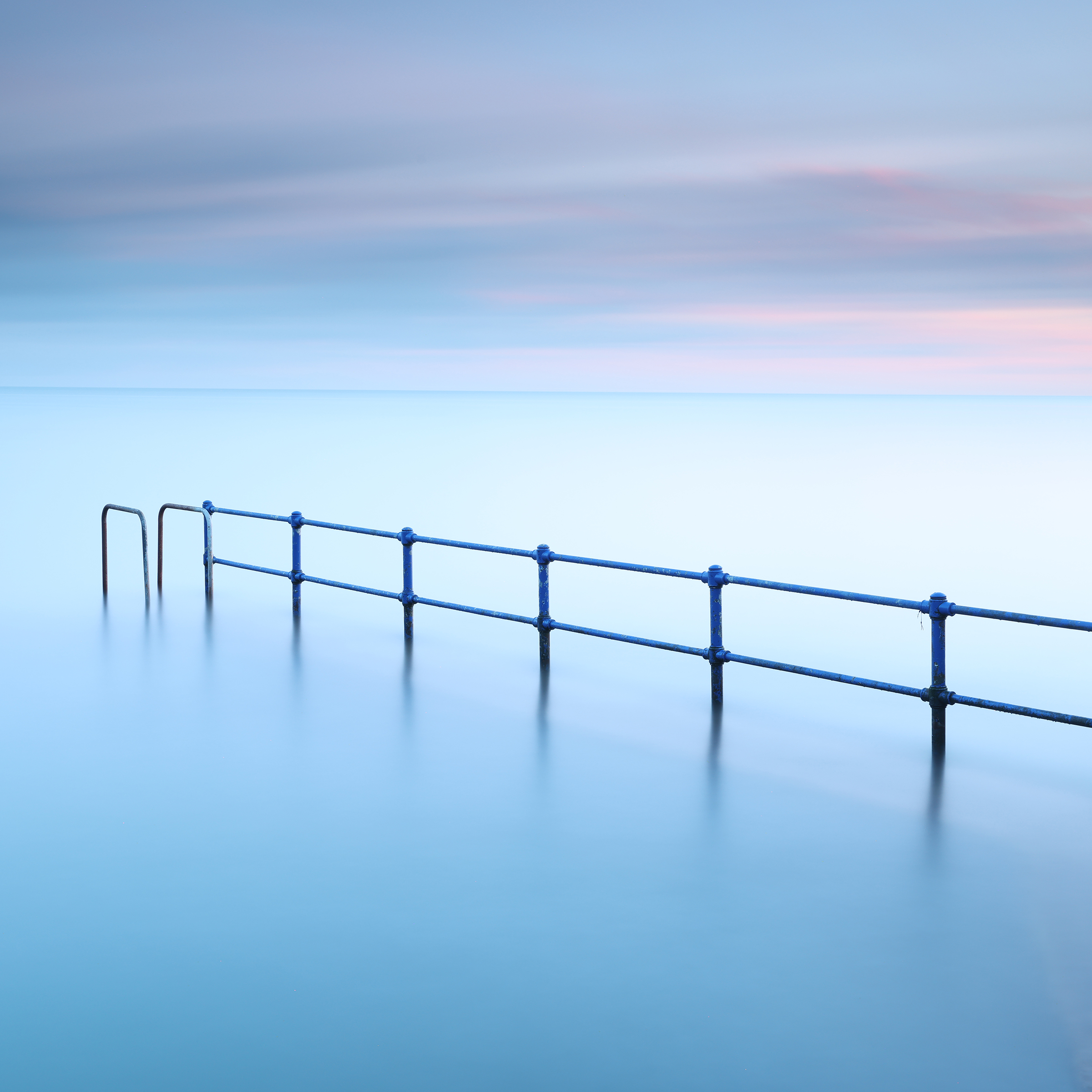 Blue Rail — submerged railings fading into calm pastel water